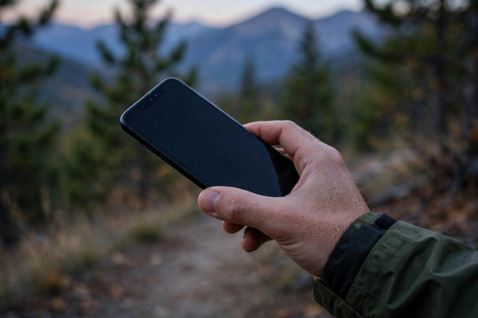 Hand holding a smartphone outdoors ready to call for help